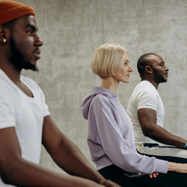 A diverse group of people sitting in a meditative yoga pose, symbolizing inclusivity.