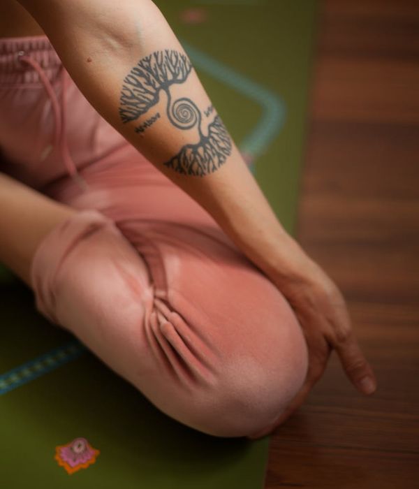 Woman practicing a focused yoga pose in a calm, dark environment with sapphire blue light.